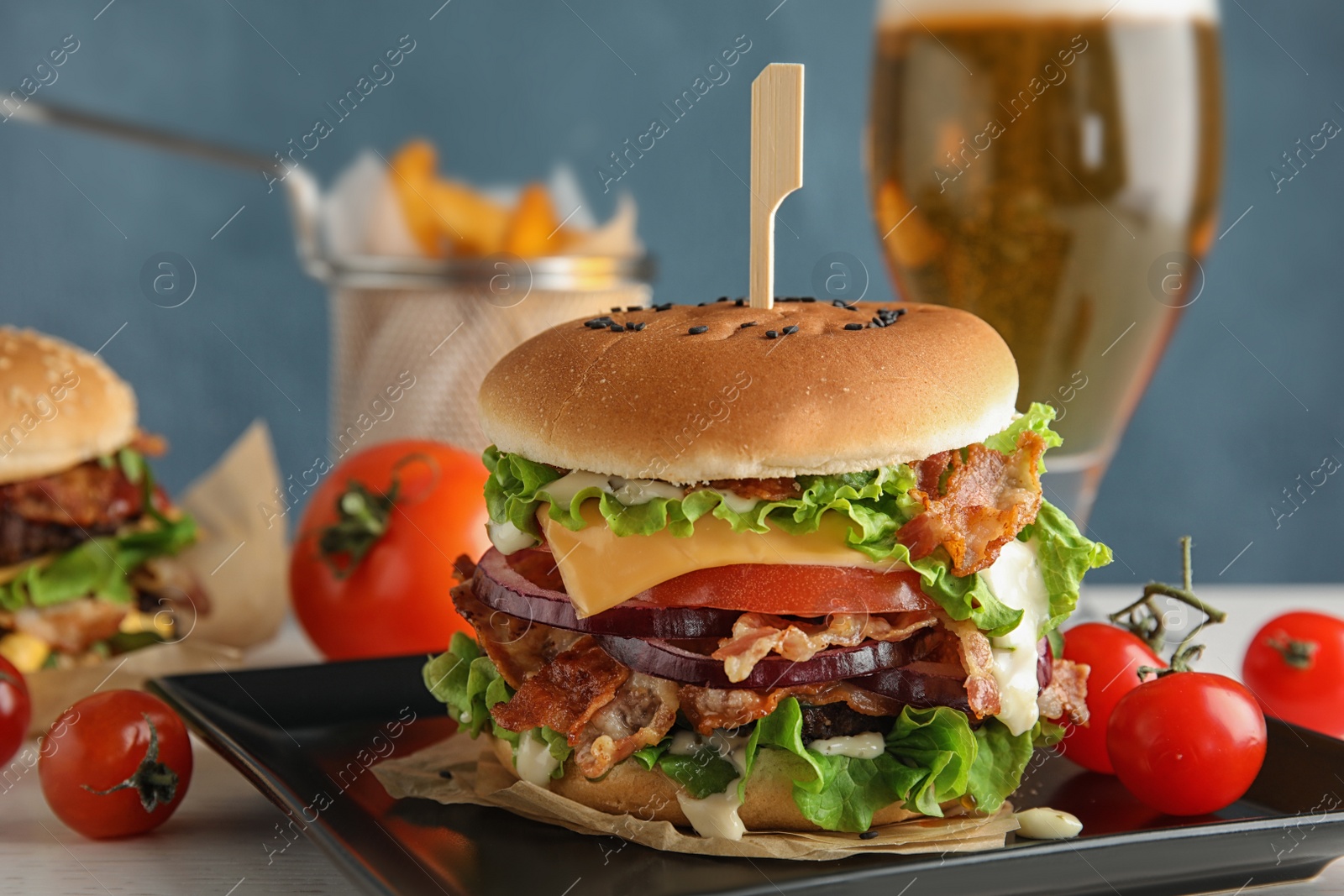 Photo of Tasty burger with bacon served on table