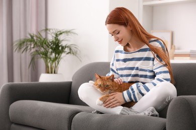 Photo of Woman with her cute cat on sofa at home