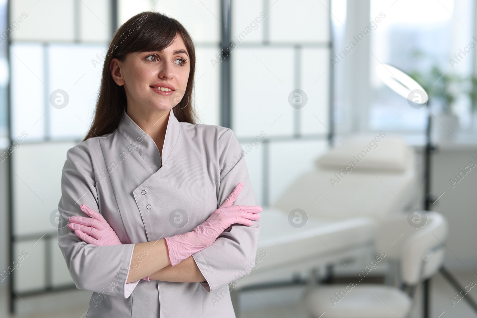 Photo of Cosmetologist in medical uniform in clinic, space for text