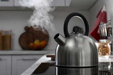 Photo of Steaming kettle on electric stove in kitchen