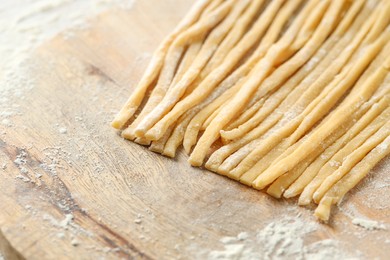 Raw homemade pasta and flour on table, closeup. Space for text