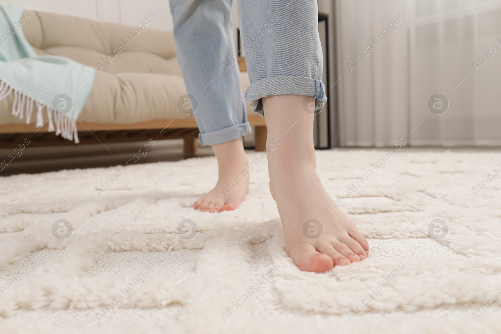 Photo of Woman standing on beige carpet in room, closeup