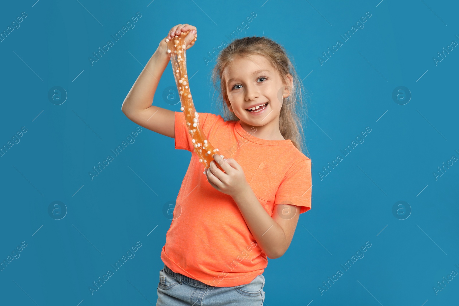 Photo of Little girl with slime on blue background