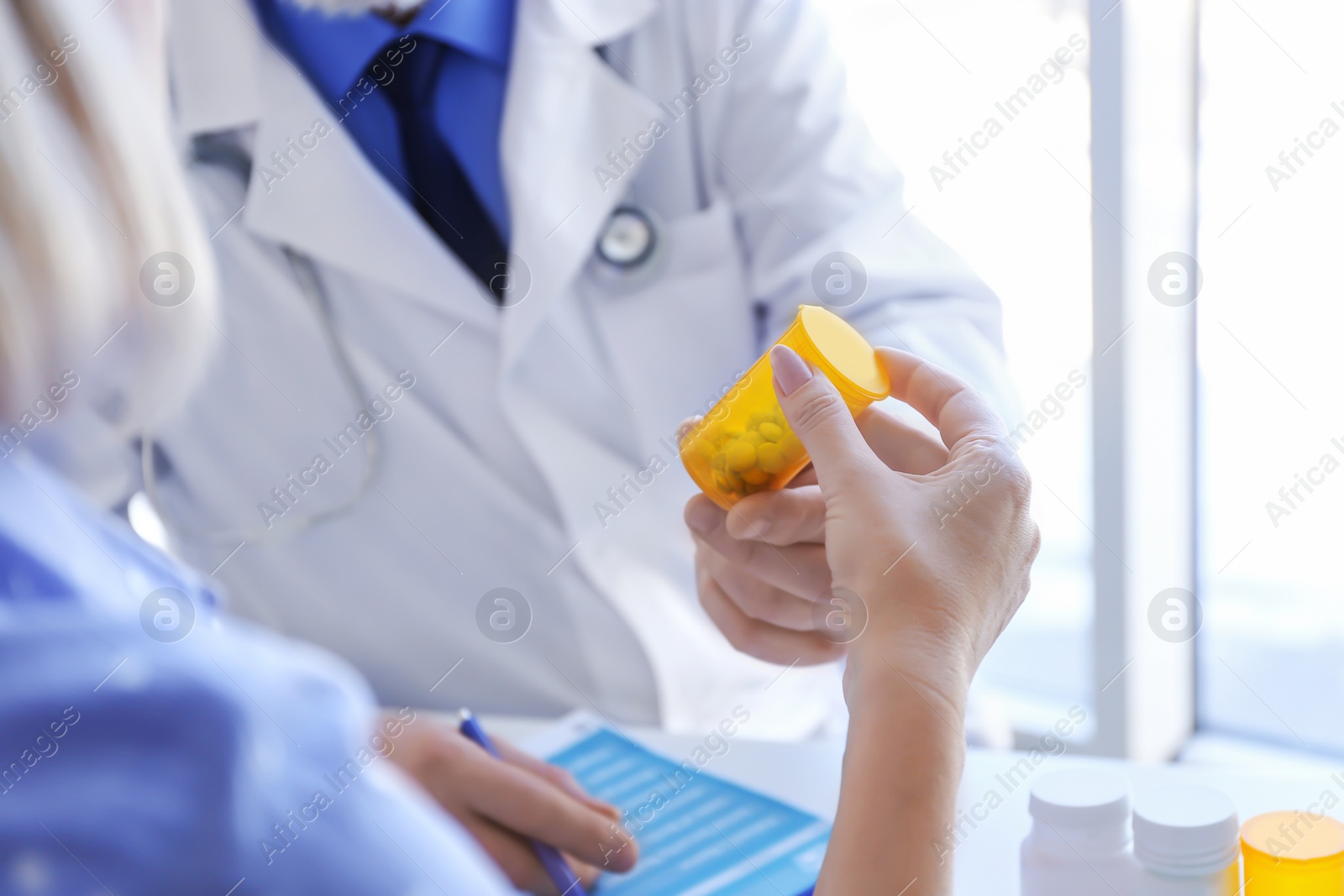 Photo of Mature doctor consulting patient in clinic, closeup