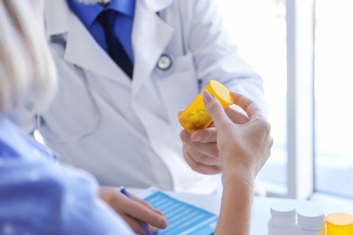 Photo of Mature doctor consulting patient in clinic, closeup