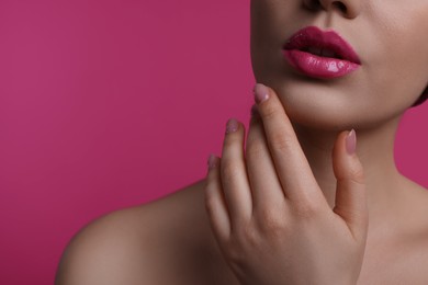 Closeup view of woman with beautiful full lips on pink background, space for text