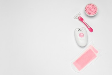 Photo of Flat lay composition with epilator and other hair removal products on white background. Space for text