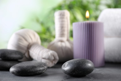 Composition with stones and spa accessories on black table against blurred background. Space for text