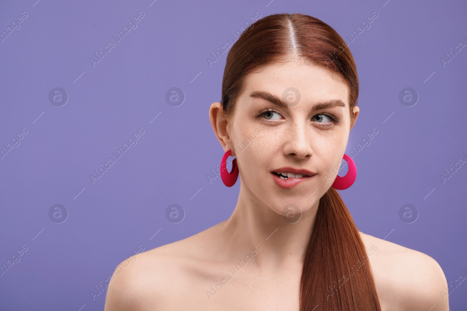 Photo of Portrait of beautiful woman with freckles on purple background. Space for text