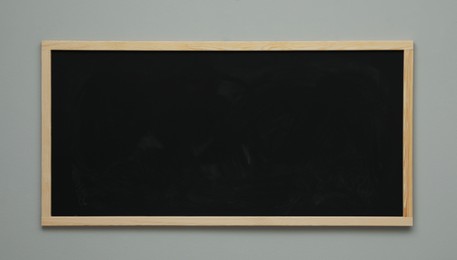 Clean black chalkboard hanging on grey wall