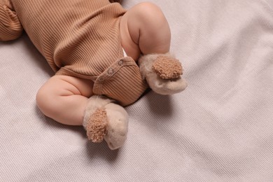 Photo of Newborn baby lying on brown blanket, top view. Space for text