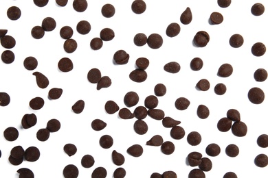 Photo of Delicious dark chocolate chips on white background, flat lay