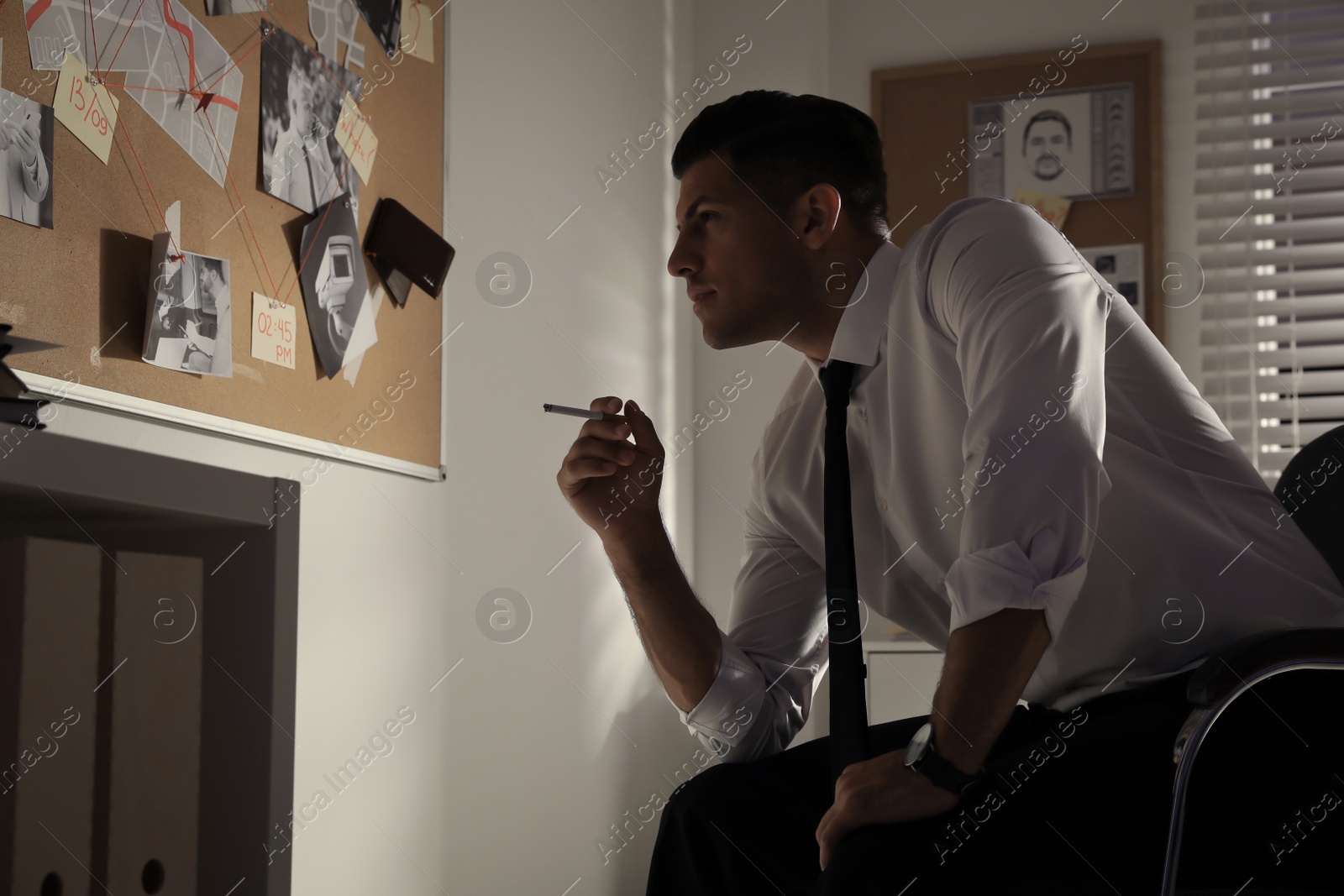 Photo of Detective looking at evidence board in office