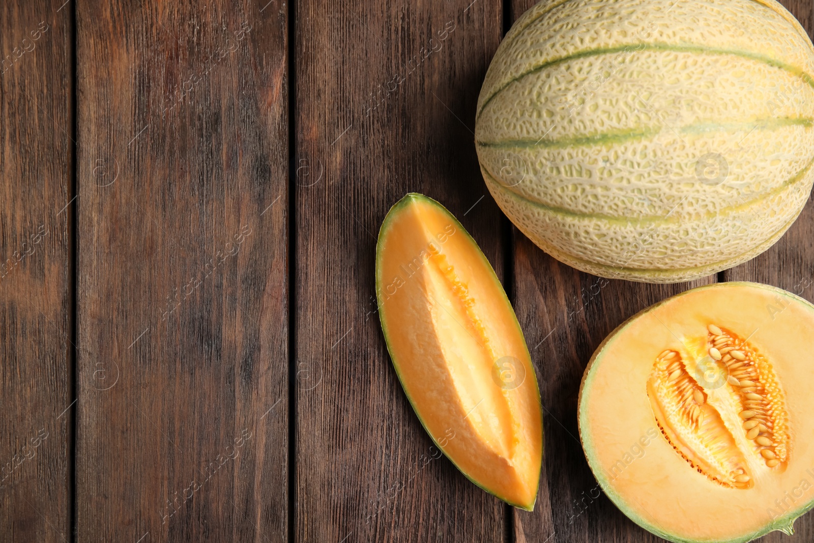 Photo of Tasty fresh melons on wooden table, flat lay. Space for text