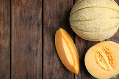 Tasty fresh melons on wooden table, flat lay. Space for text