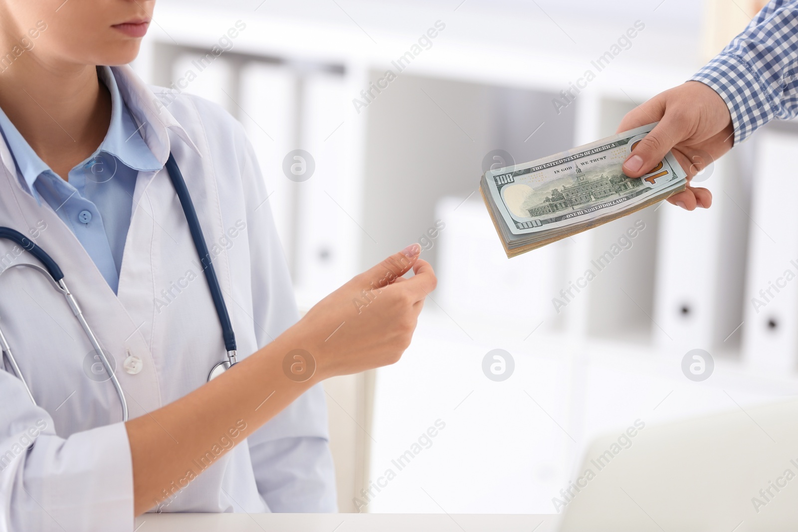 Photo of Patient giving bribe to doctor in clinic, closeup. Corrupted medicine