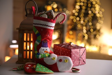 Stocking, sweets, gift box and lantern on table. Saint Nicholas Day tradition