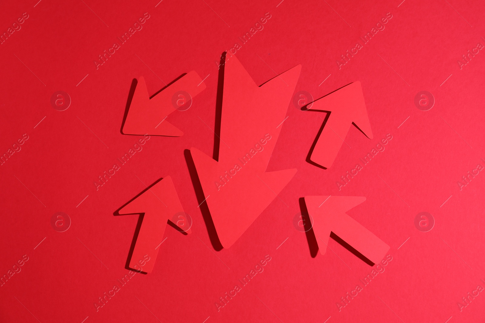 Photo of Many paper arrows on red background, flat lay