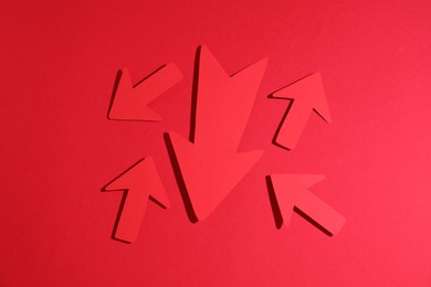 Many paper arrows on red background, flat lay