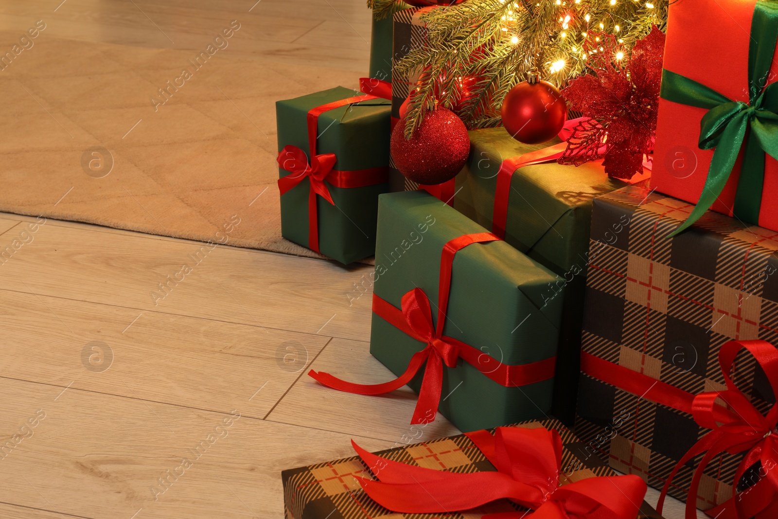 Photo of Many gift boxes under decorated Christmas tree indoors, space for text