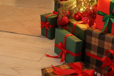 Many gift boxes under decorated Christmas tree indoors, space for text