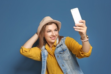 Photo of Attractive young woman taking selfie on color background