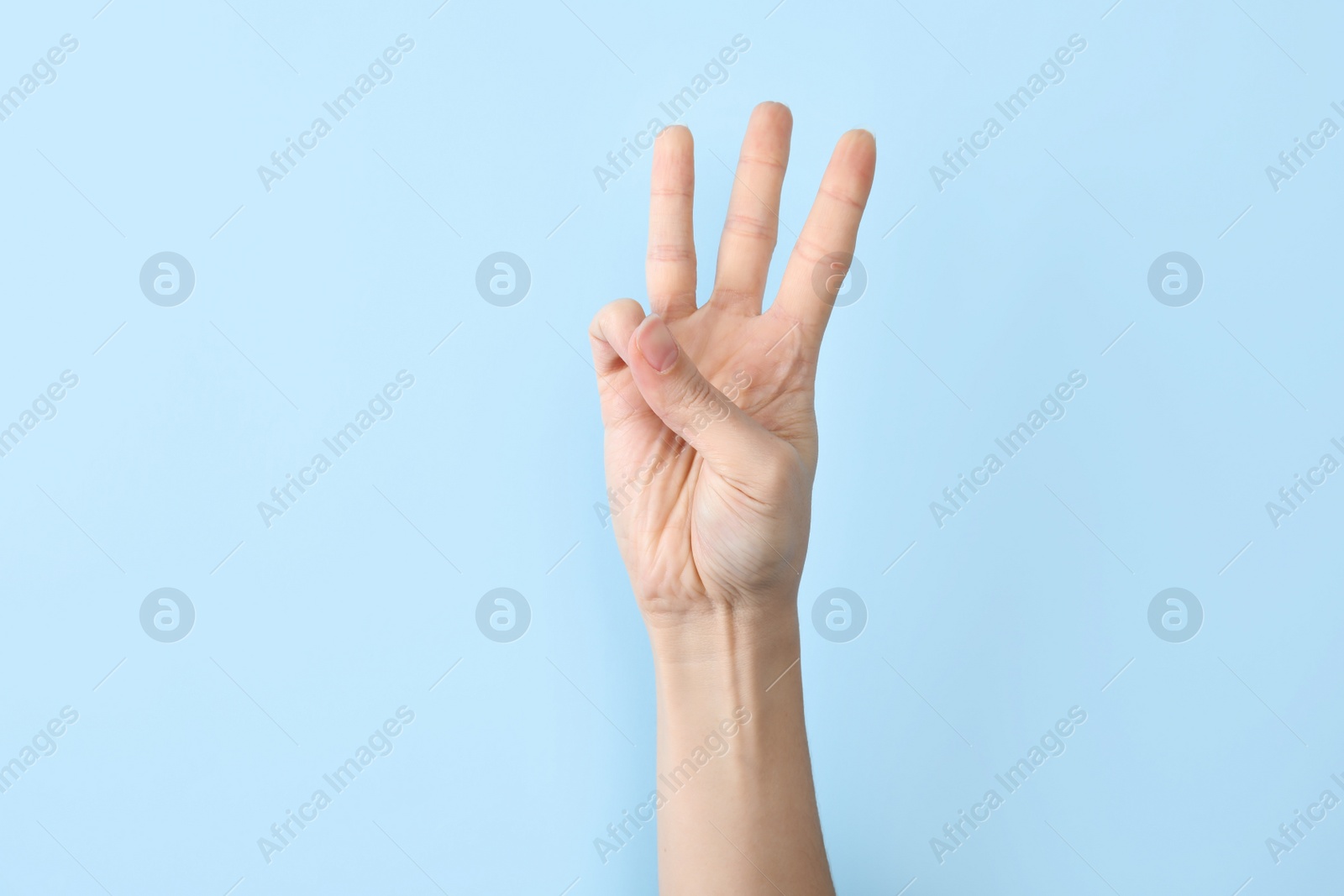 Photo of Woman showing W letter on color background, closeup. Sign language