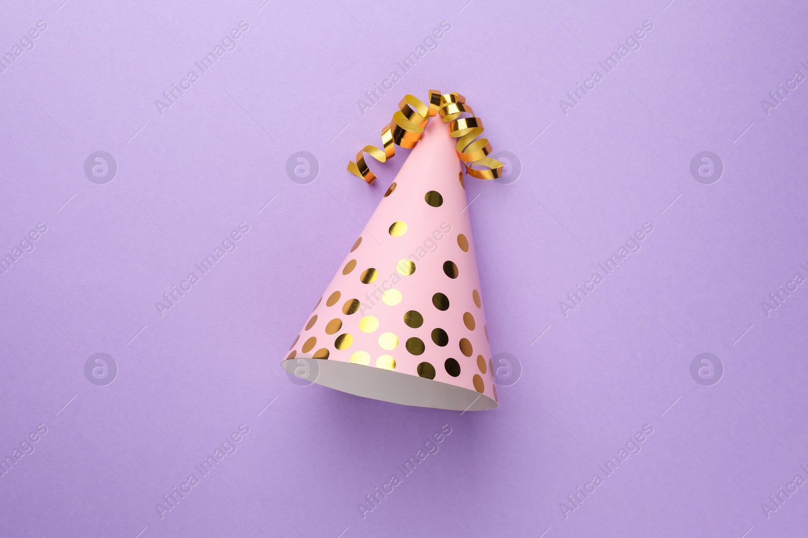 Photo of One pink party hat with serpentine streamers on purple background, top view