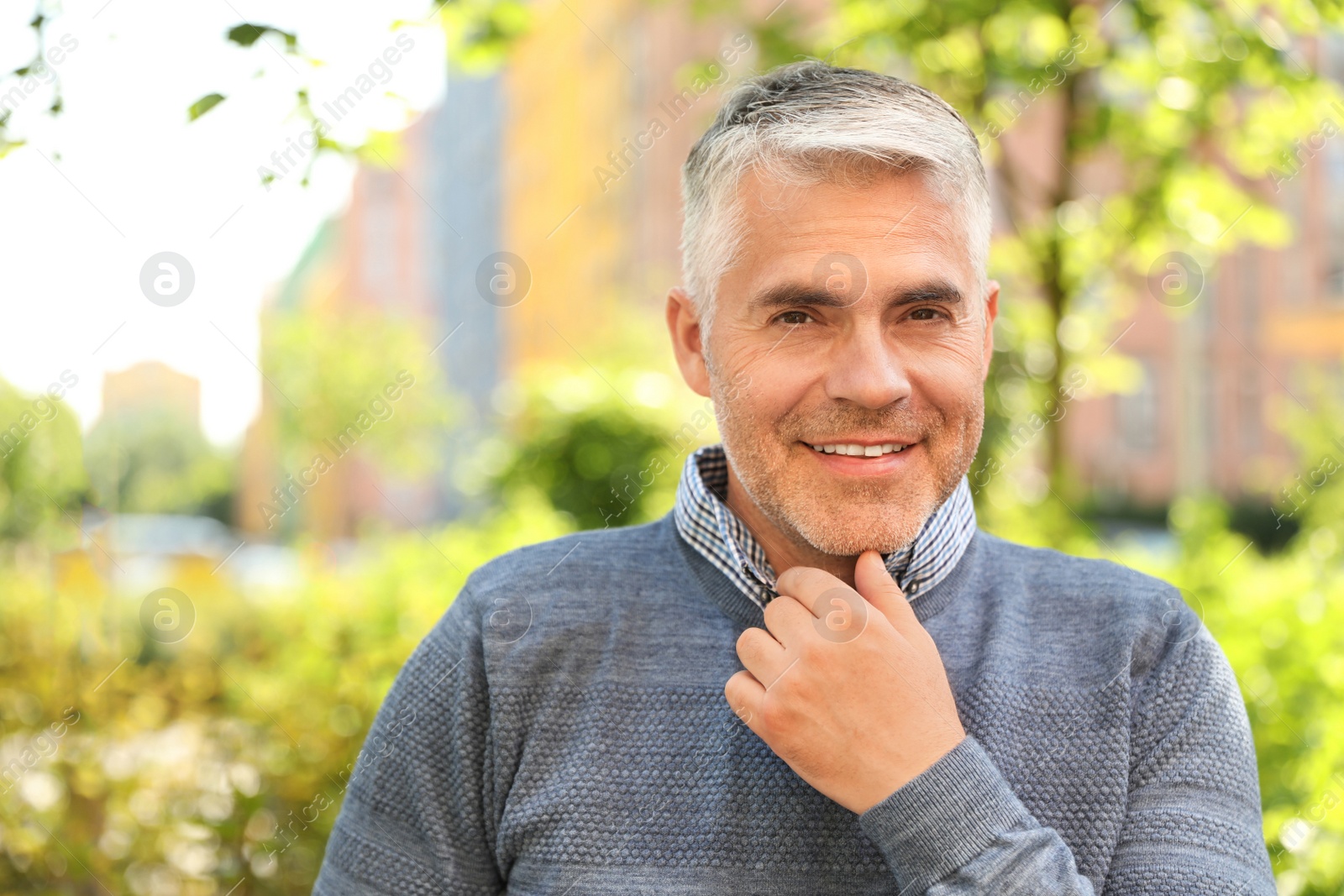 Photo of Portrait of handsome mature man in park. Space for text