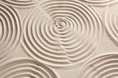 Photo of Beautiful spirals on sand, above view. Zen garden