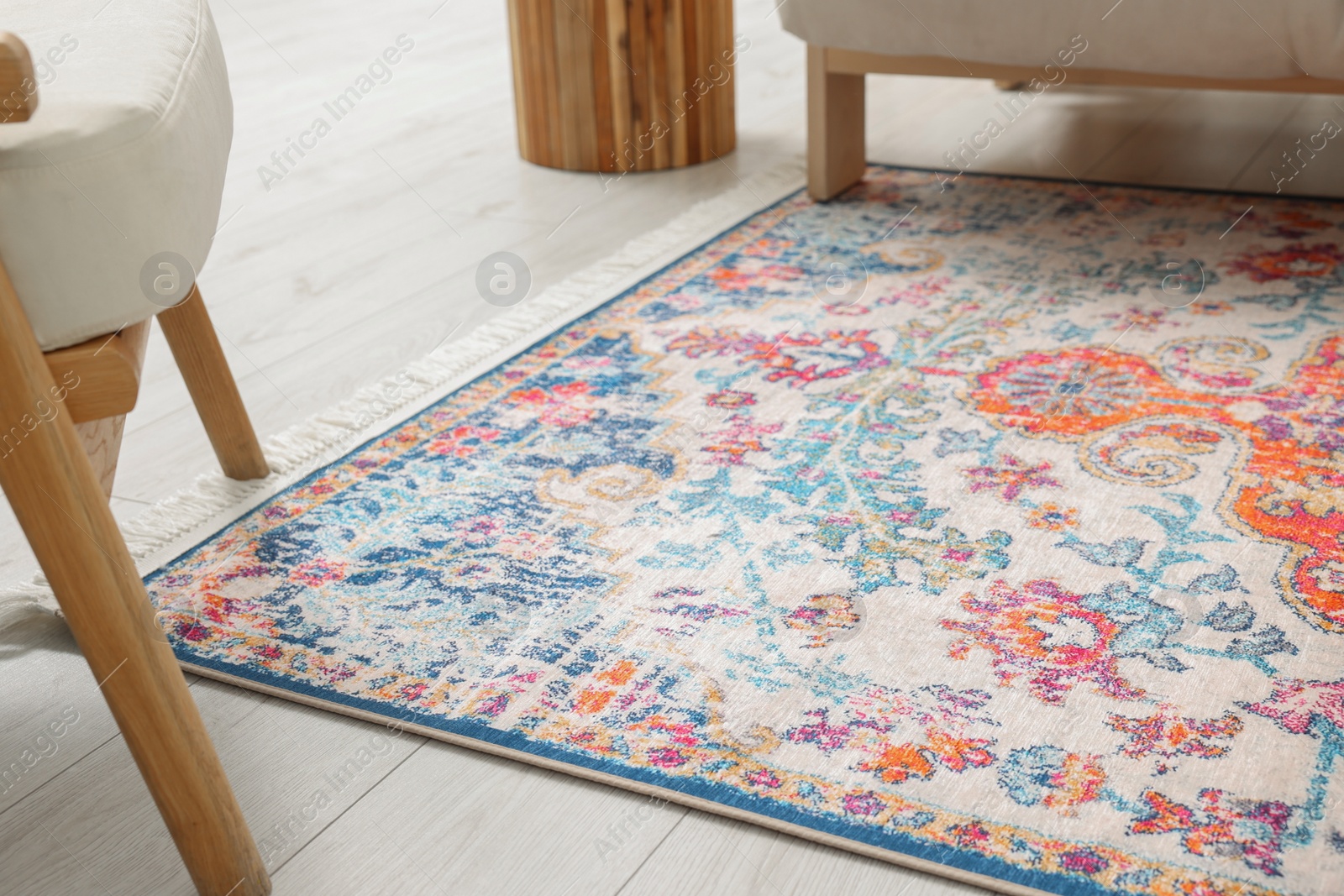 Photo of Beautiful rug on wooden floor in living room