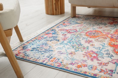 Photo of Beautiful rug on wooden floor in living room