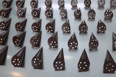 Many tasty chocolate candies on metal surface. Production line