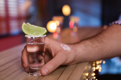Photo of Man with shot of Mexican Tequila at bar, closeup