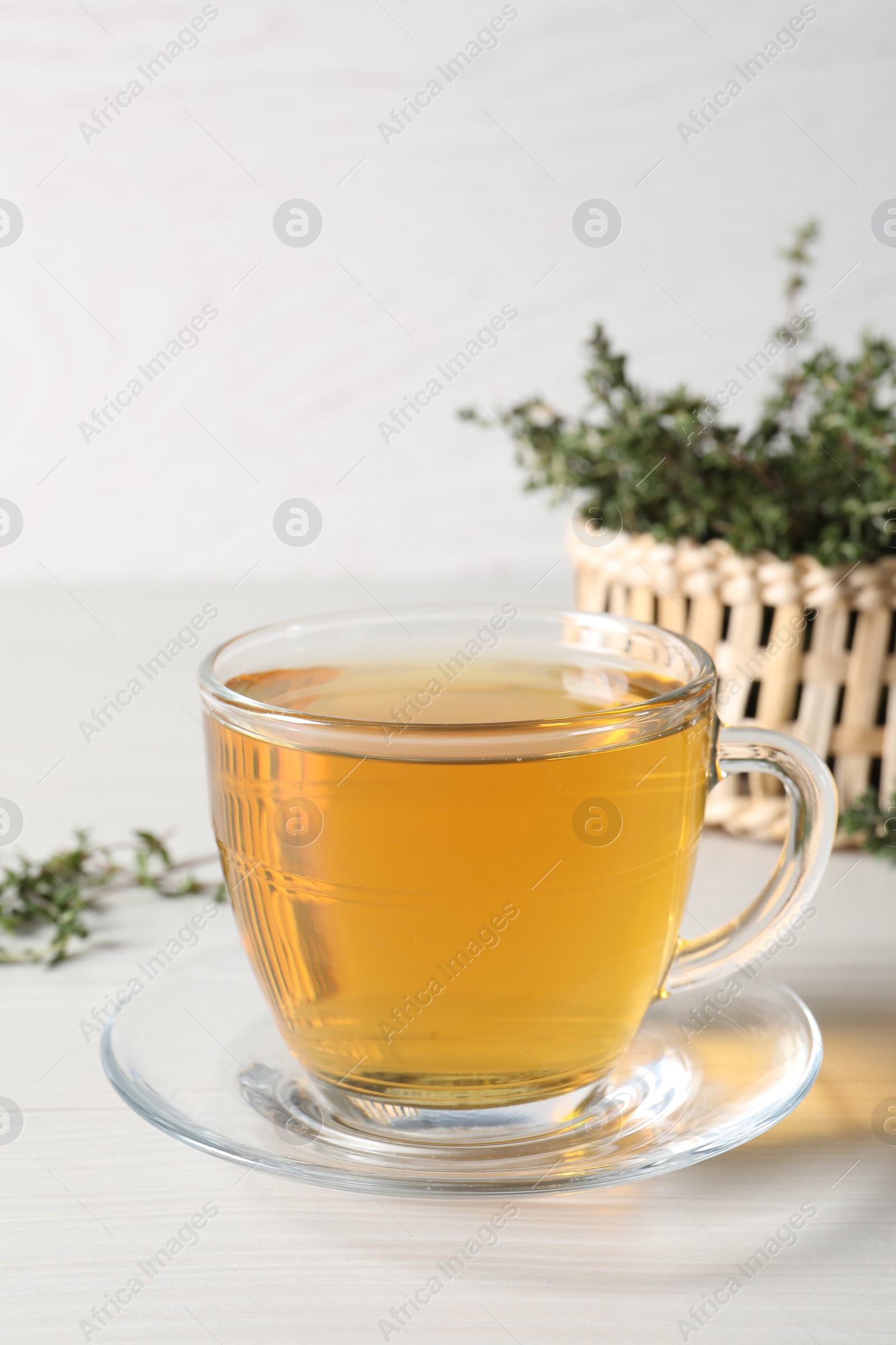 Photo of Aromatic herbal tea with thyme on white wooden table