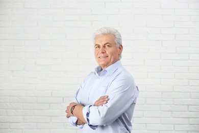 Photo of Portrait of handsome mature man near brick wall