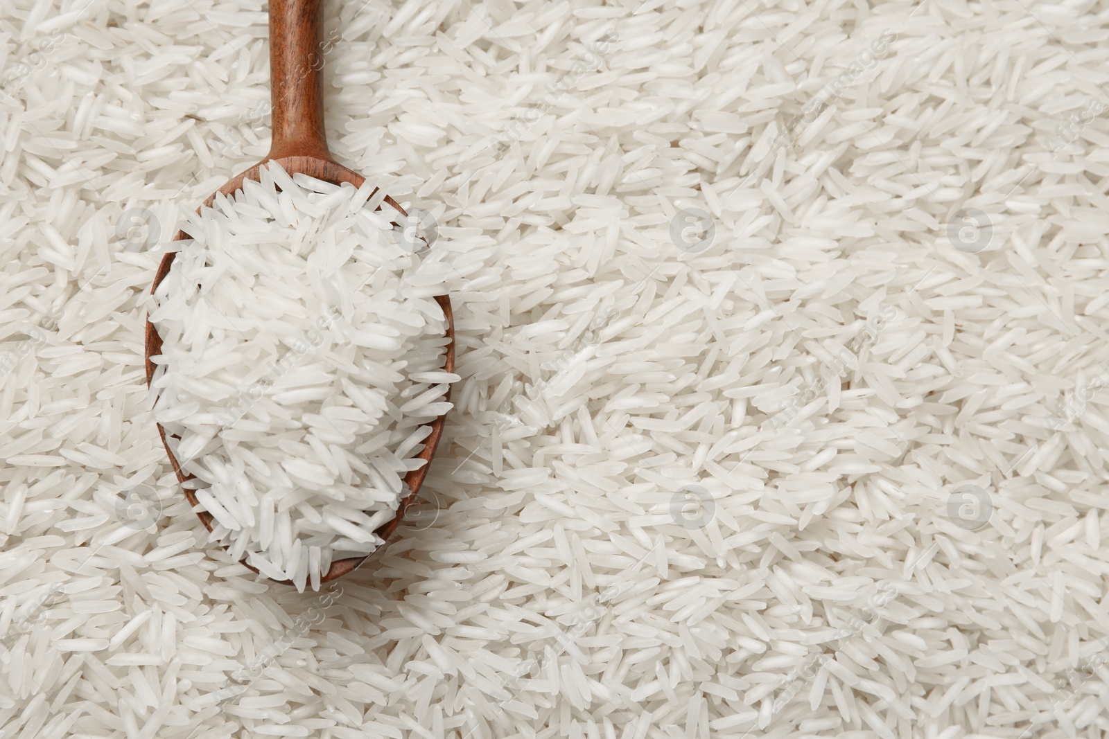 Photo of Raw basmati rice and spoon as background, top view