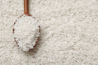 Photo of Raw basmati rice and spoon as background, top view