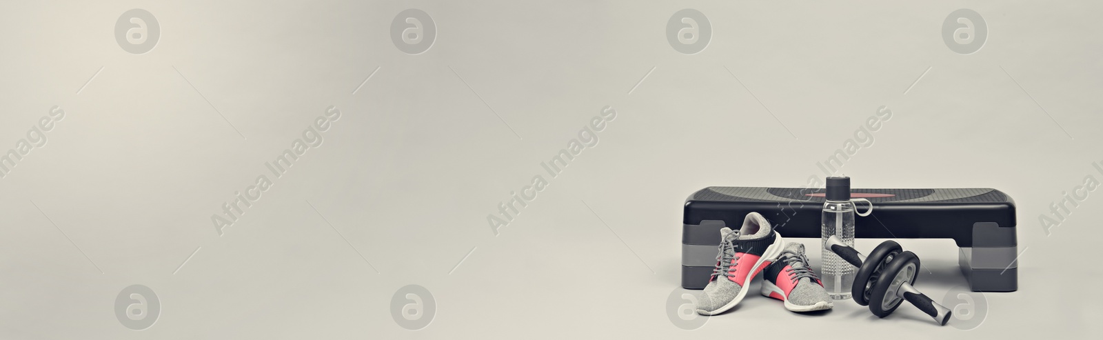 Image of Step platform, abdominal wheel, water bottle and sneakers on light background, space for text. Banner design