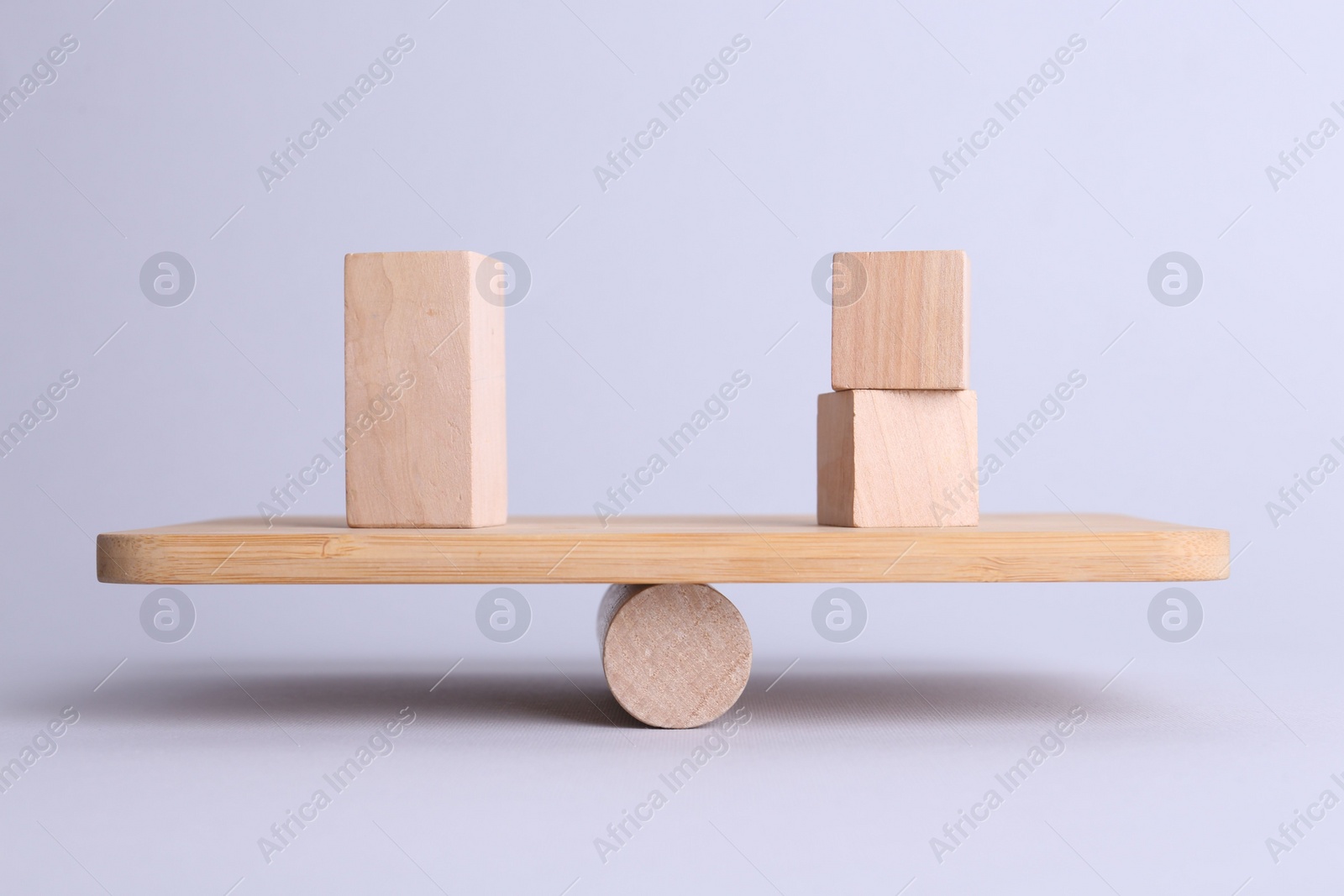 Photo of Equality concept. Seesaw scale with wooden blocks on light background