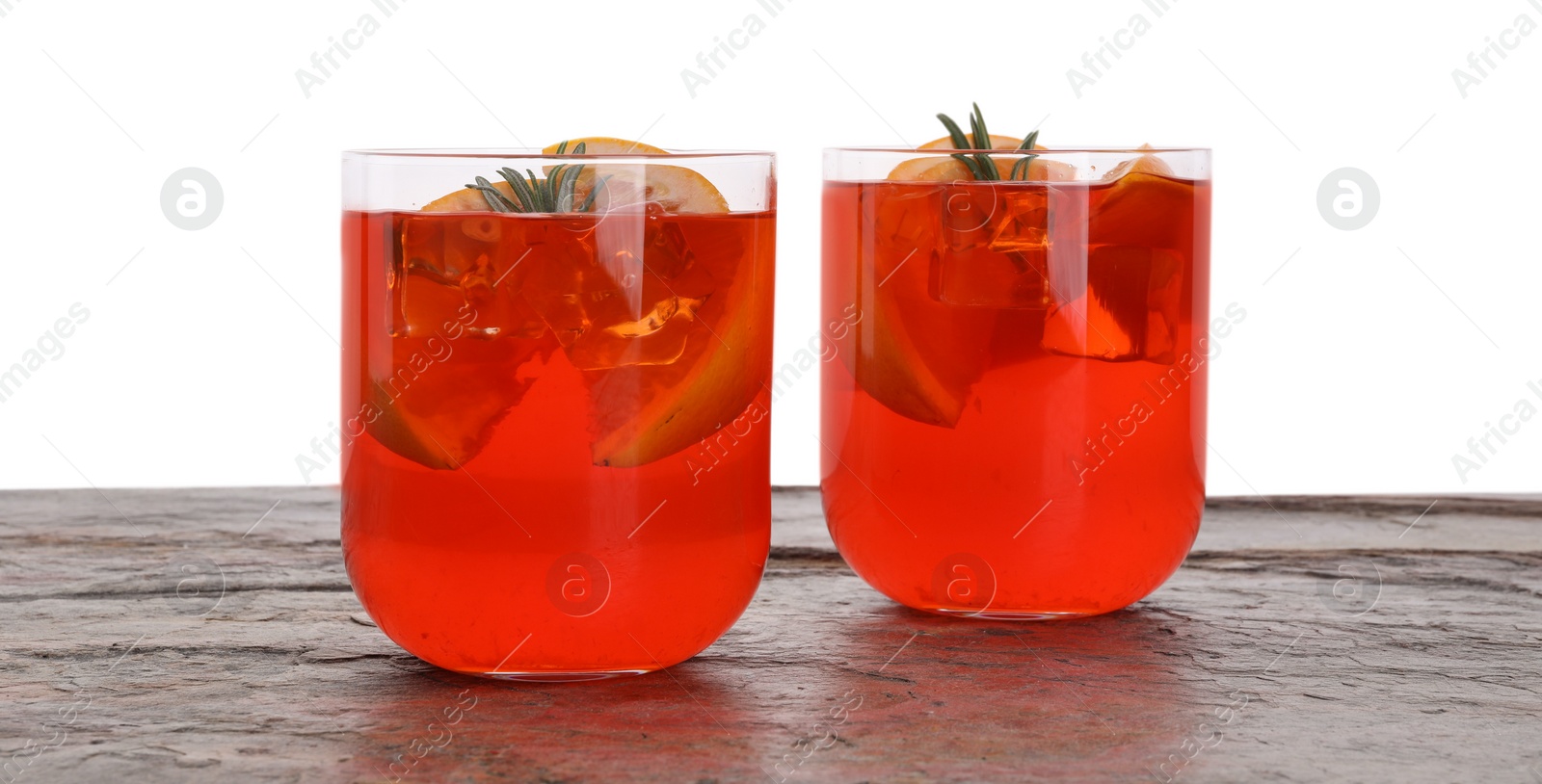 Photo of Aperol spritz cocktail, orange slices and rosemary in glasses on grey textured table against white background