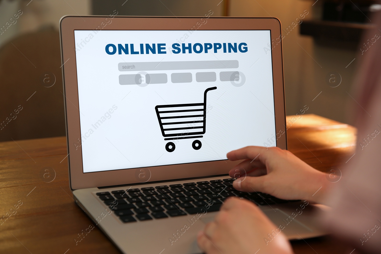 Image of Woman using laptop for online shopping at wooden table, closeup