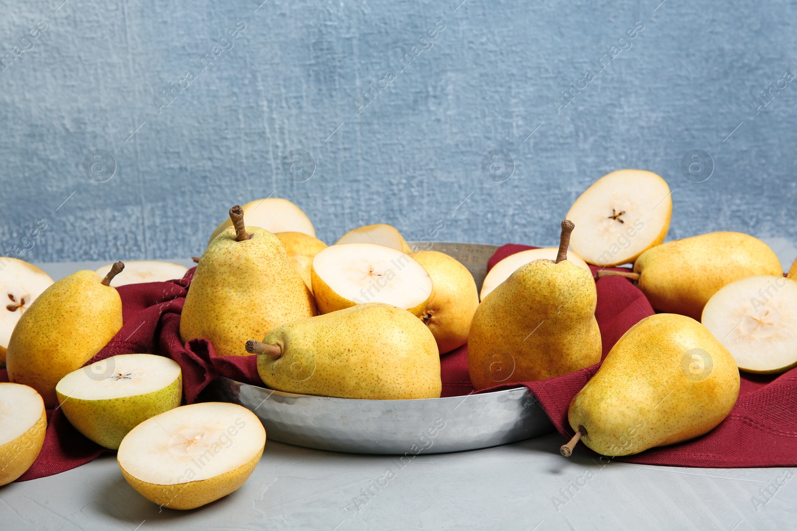 Photo of Fresh ripe pears on table against color background