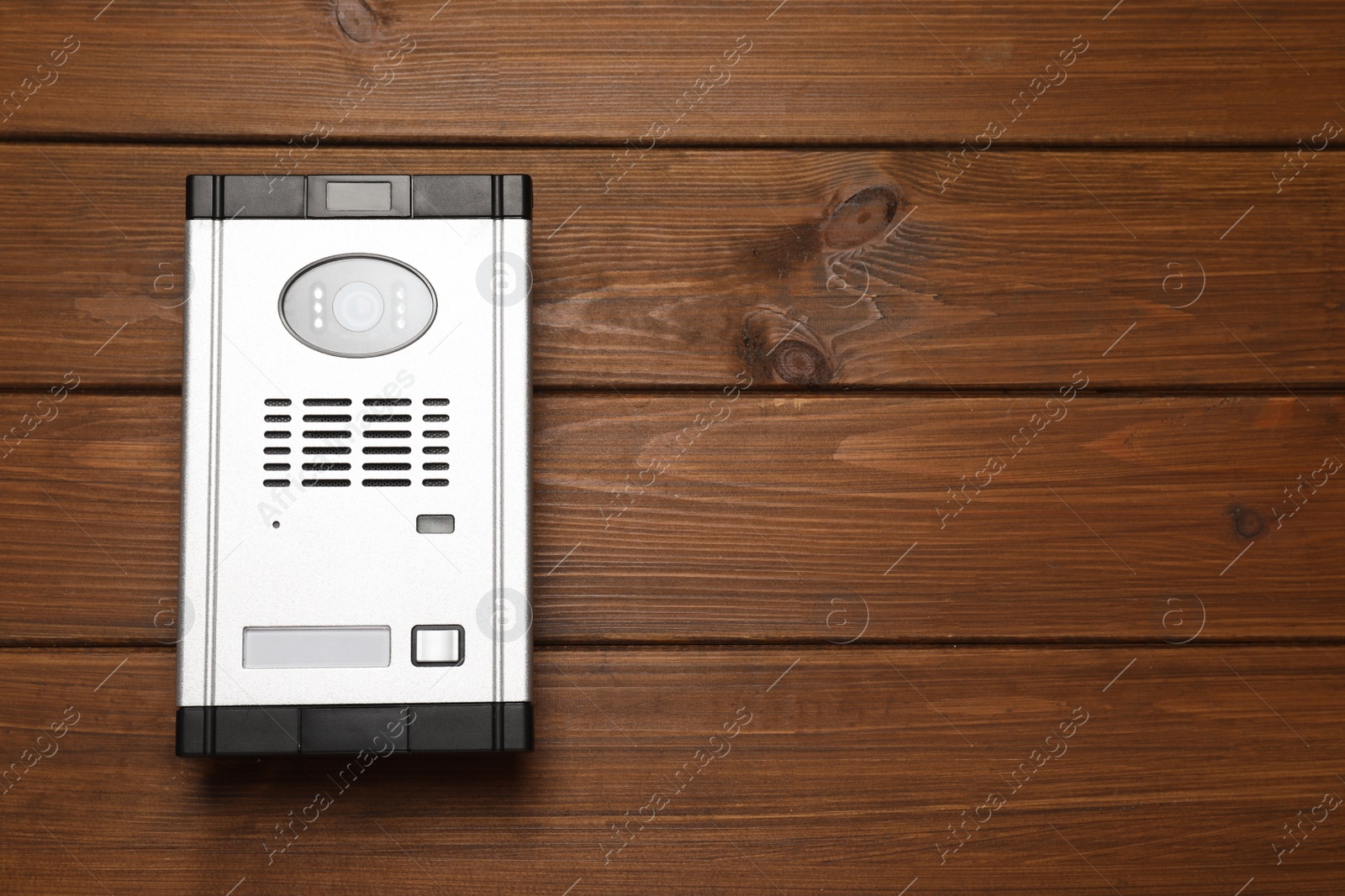 Photo of Modern intercom system with camera on wooden background, top view. Space for text