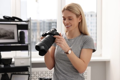 Professional photographer with modern digital camera in office