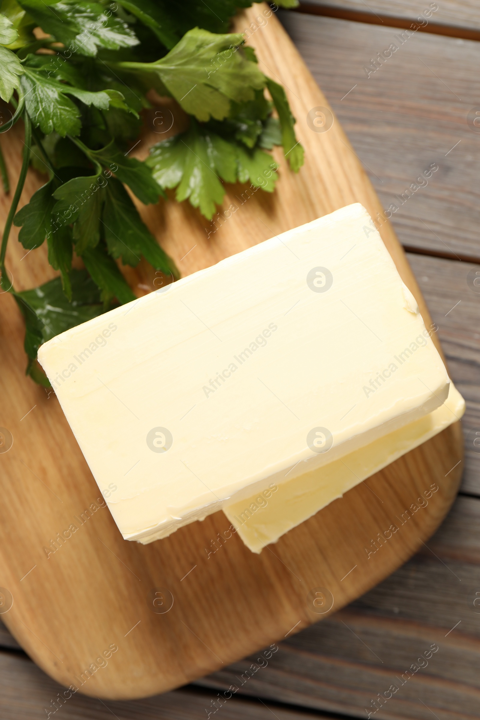 Photo of Tasty butter and parsley on wooden table, top view