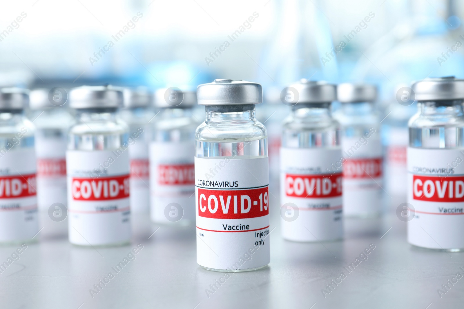 Photo of Glass vials with COVID-19 vaccine on light table