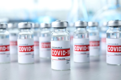 Photo of Glass vials with COVID-19 vaccine on light table