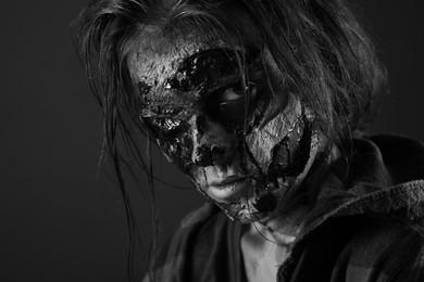 Photo of Scary zombie on dark background, black and white effect. Halloween monster