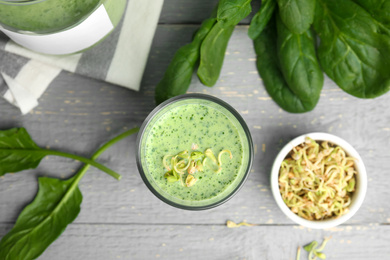 Photo of Green buckwheat smoothie on light grey wooden table, top view